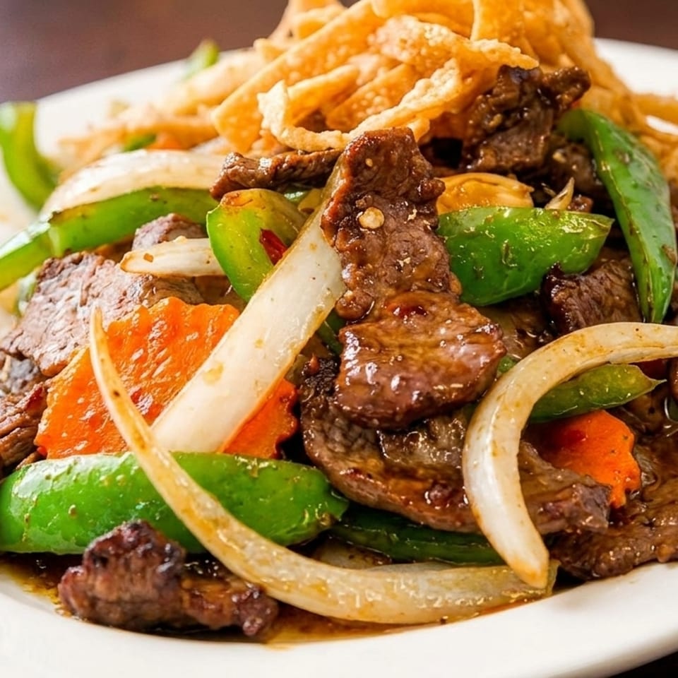 Thai Mongolian beef stir-fried with green bell peppers, onions, carrots, and crispy noodles.