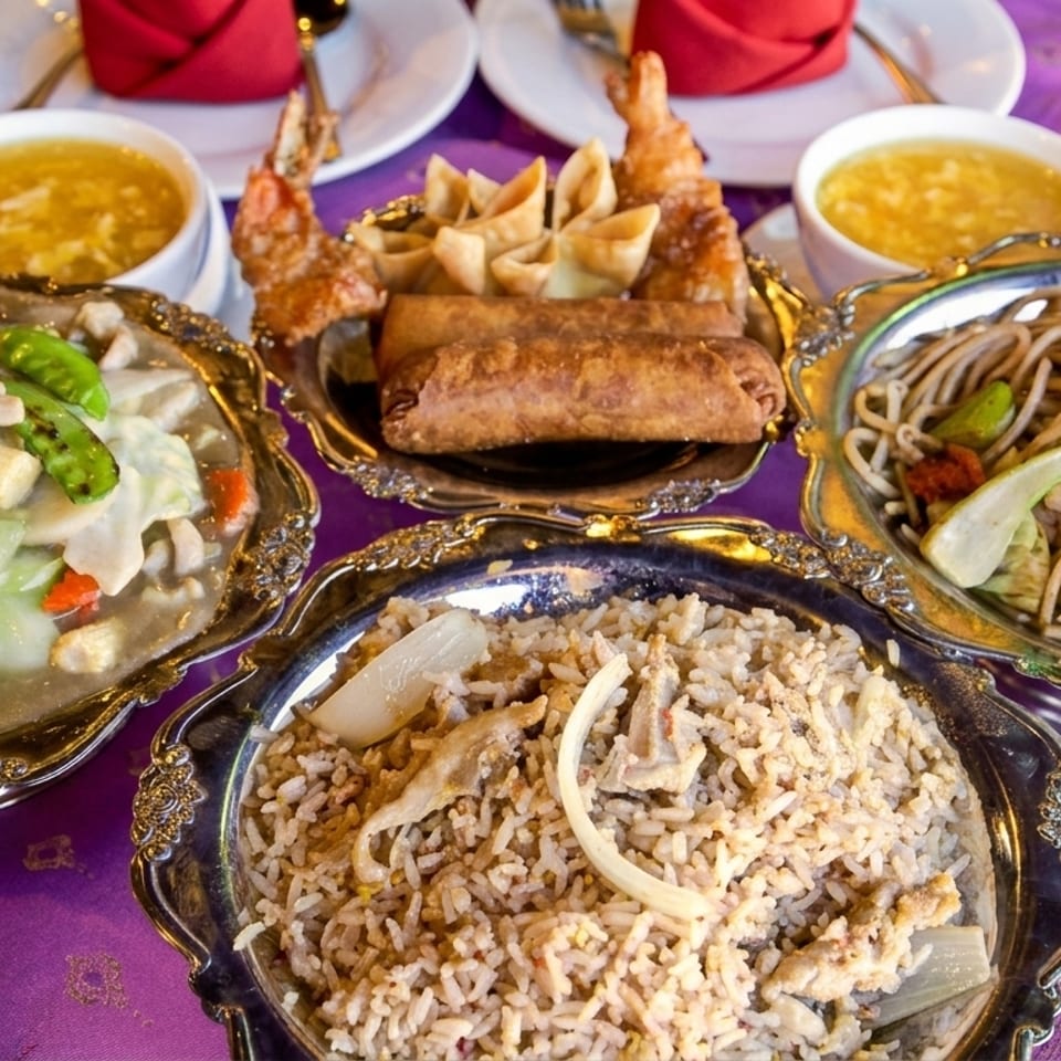A vibrant spread of Chinese dishes, including stir-fry, fried rice, noodles, egg rolls, and soup.